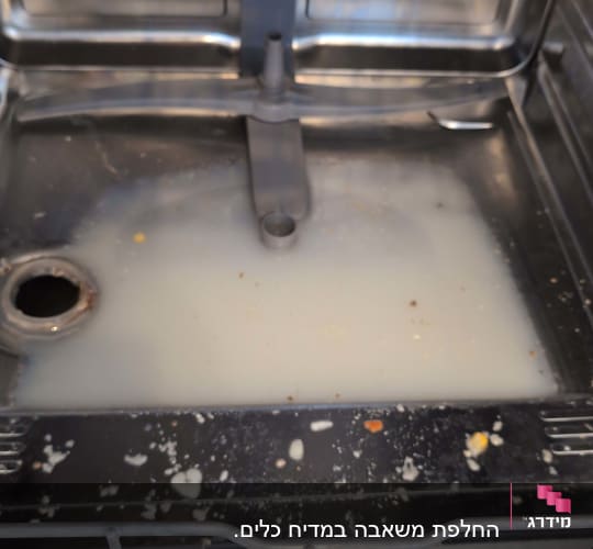 פנים מדיח כלים עם מים מלוכלכים ושאריות מזון